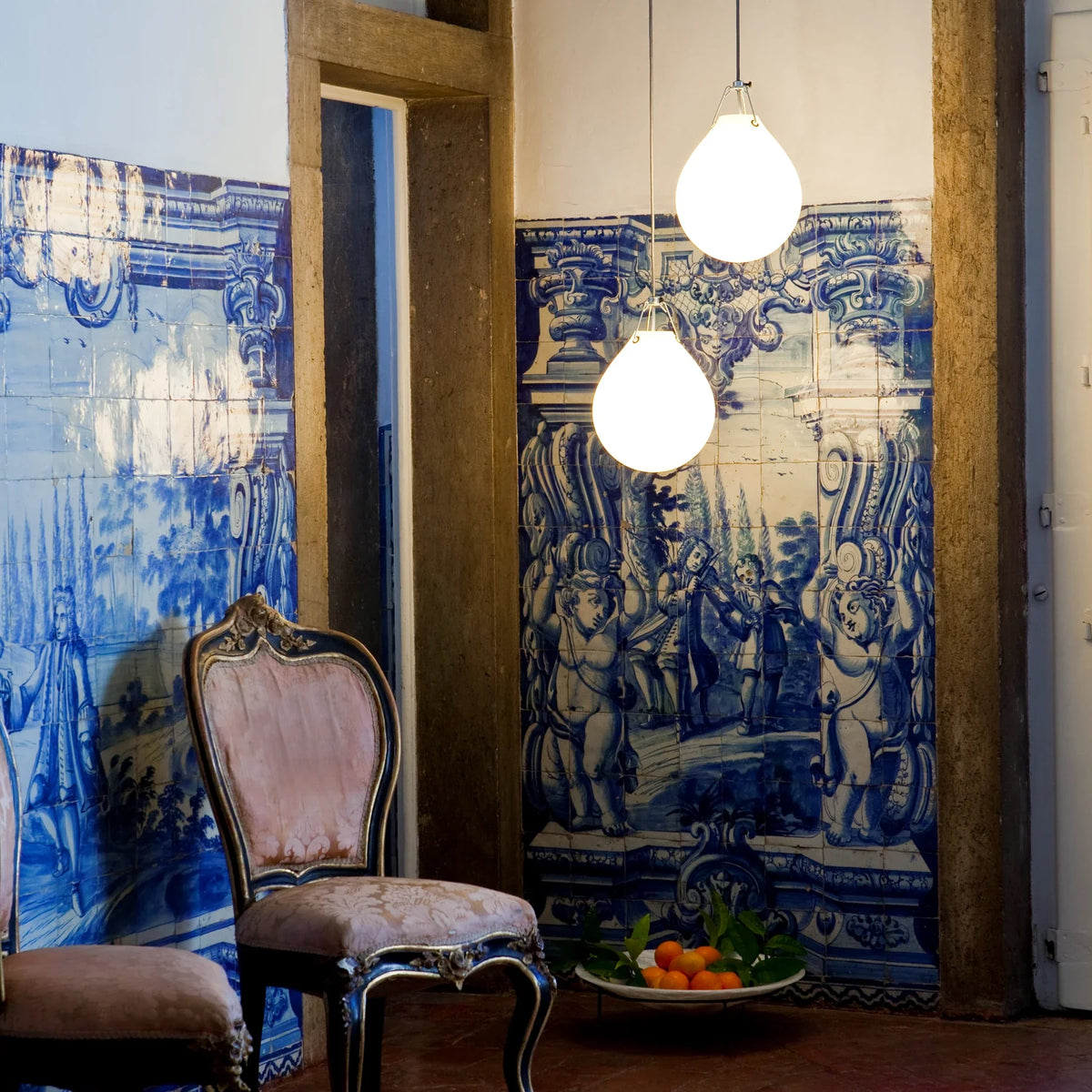 Two Moser Pendants in white opal glass hanging at different heights against blue azulejo tiles in Palácio Belmonte, Lisbon
