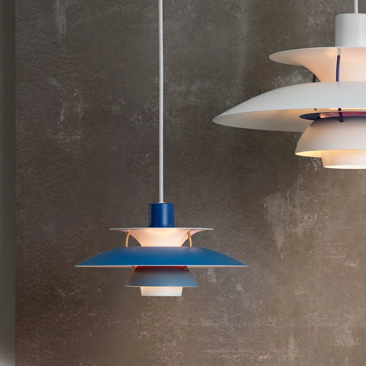Louis Poulsen PH 5 Mini pendant in blue in front of a full-size white PH 5