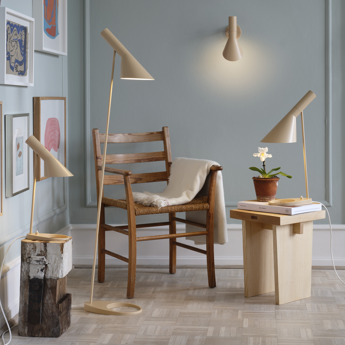 AJ floor, table and wall lamps in warm sand around a wooden chair and side table