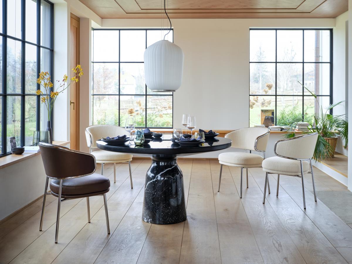 Plissée Pendant Lamp in white pleated opal glass hanging over a round dining table by tall windows