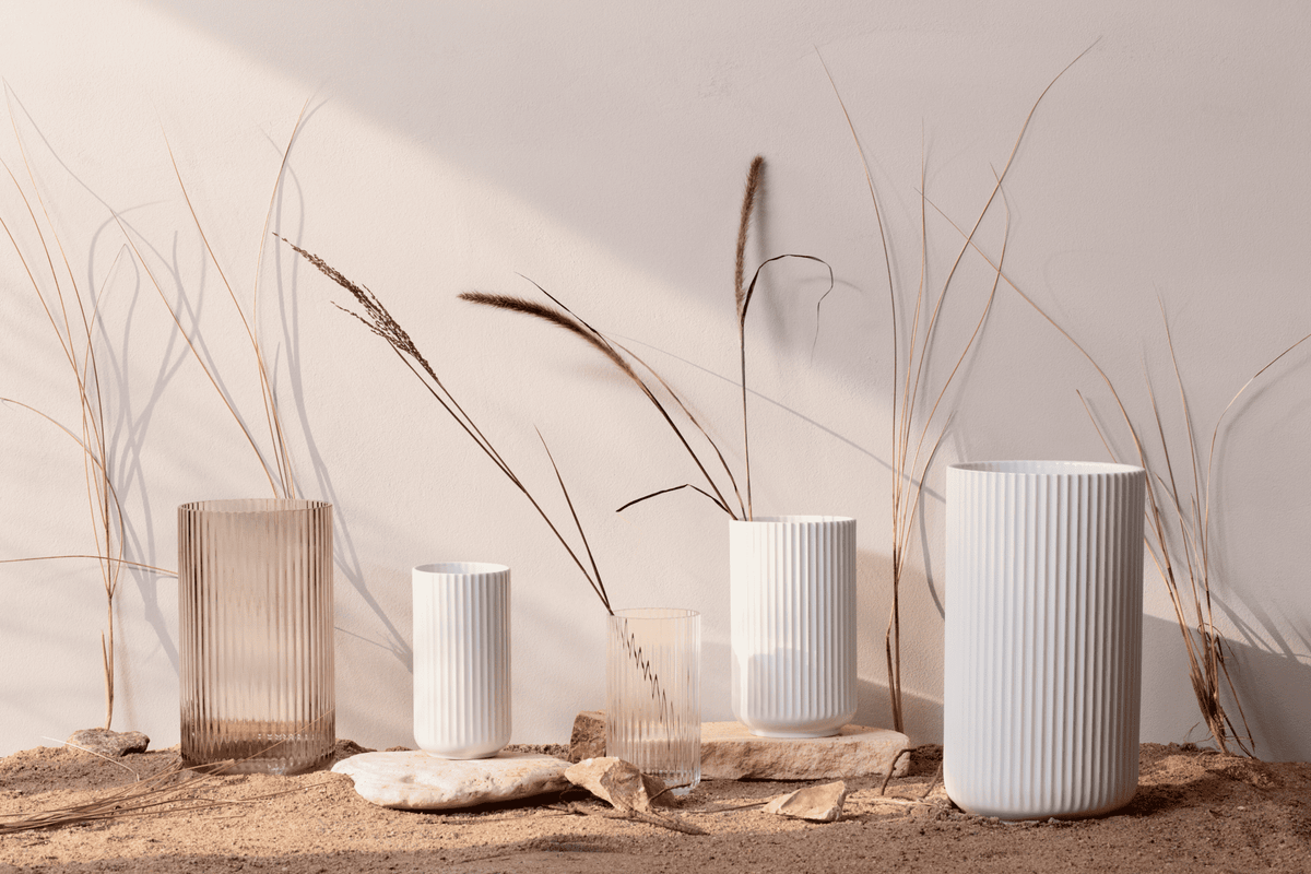White porcelain Lyngby vases in several heights with dried grasses on a sandy surface
